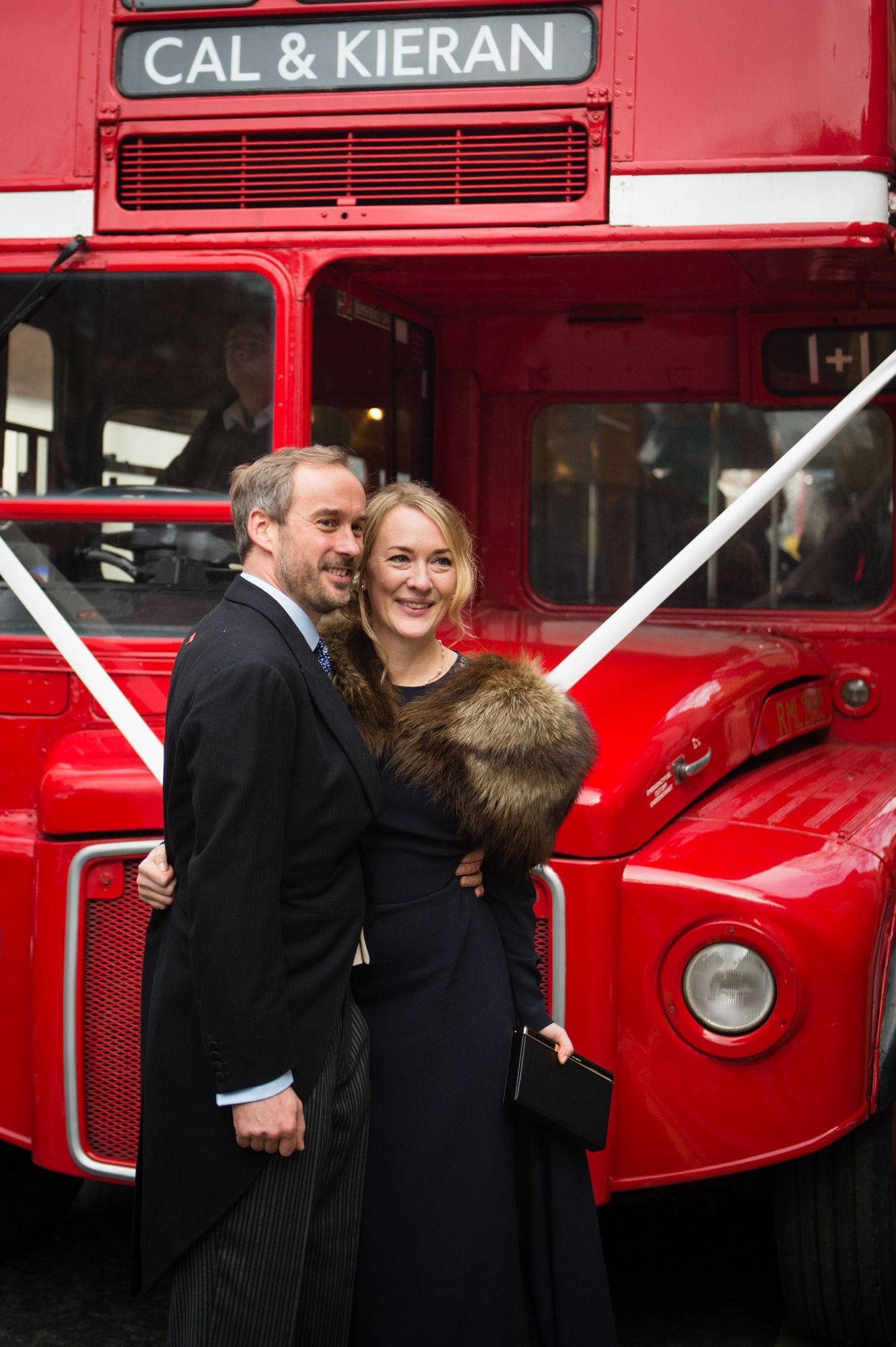 bride and groom with red london bus on their wedding day in chelsea